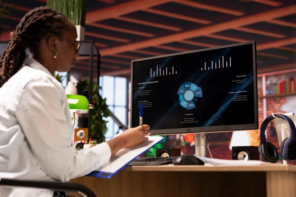 Woman analyzing a restaurant revenue pie chart on a computer.